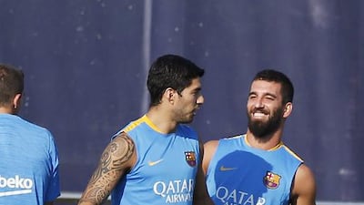 Arda Turan, right, and Luis Suarez share a joke during training. Josep Lago / AFP / July 13, 2015