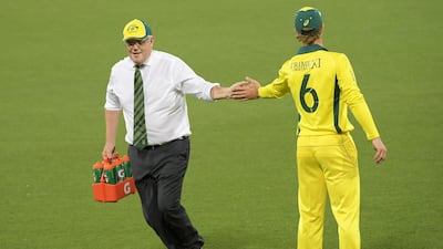 Australia PM Scott Morrison carries drinks during the tour match at the Manuka Oval. Getty Images
