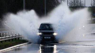 Cars pass through floodwater in Cirencester, western England, after Storm Henk brought strong winds and heavy rain across much of the country. AFP