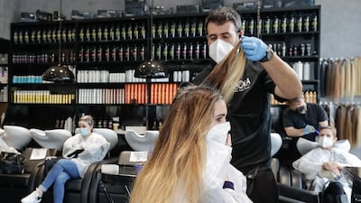 A hairdresser serves a customer in Naples, Italy, as the town is downgraded from a red to an orange zone, after weeks of tight restrictions to fight the coronavirus disease outbreak. Reuters