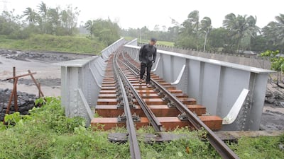 A man walks along a destroyed rail bridge in Guinobatan town, south of Manila. AFP