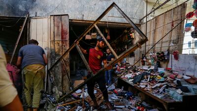 People pick up debris at the site of an explosion in the Sadr City district of Baghdad.