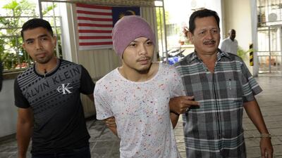 Wee Meng Chee, centre, a Malaysian rapper popularly known as Namewee, is escorted by plainclothes policemen as he arrives at the magistrate court in Penang, Malaysia. Gary Chuah / AP Photo