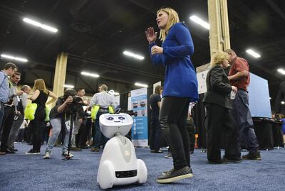A woman plays with Buddy the companion robot by Blue Frog Robotics. AFP