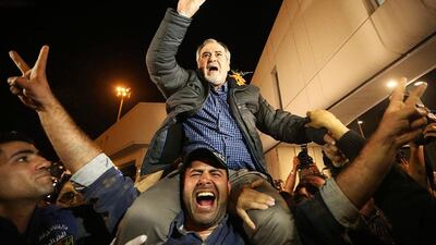 One of the nine newly released Lebanese hostages, who were held by rebels in northern Syria, is carried on the shoulders of his son upon his arrival at Beirut international airport. Hasan Shaaban / Reuters