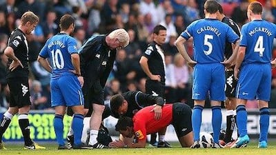 Lee Probert, the referee, centre, was knocked down during the clash between Wigan Athletic and Fulham.