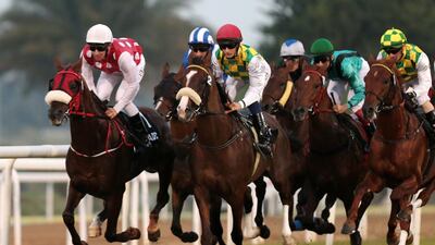 Jockey Adrie De Vries atop Abu Alabyad, left, races to victory in the President Cup Prep Race during the ninth race meeting at Abu Dhabi Equestrian Club in Abu Dhabi on February 1, 2015. Christopher Pike / The National