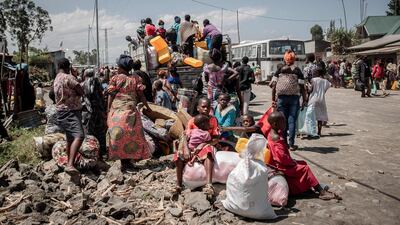 People aboard a truck in Sake with their belongings, waiting to be taken to home.