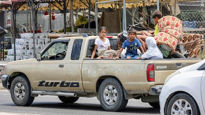 Children wait on a pick-up truck as people fleeing Tyre in southern Lebanon after Israel's forced displacement order seek refuge in Sidon on June 9. AFP
