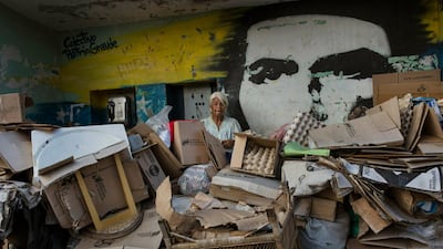 Rosa Maria Gomez, 65, poses beside a mural of revolutionary leader Ernesto Che Guevara at a makeshift shelter in the Petare neighbourhood of Caracas. AP Photo