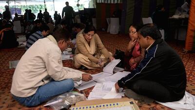 Polling officials check electoral materials on the eve of the Delhi Legislative Assembly election at a school being used as a polling station in New Delhi on Tuesday. Sajjad Hussain / AFP
