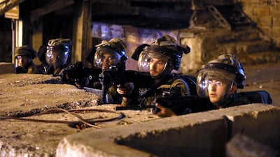 Israeli troops take position in the West Bank city of Hebron on Wednesday against Palestinian protesters supporting six prison escapees. EPA