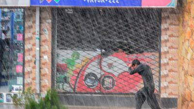 A young man runs along a street under heavy rain in Kabul. AFP