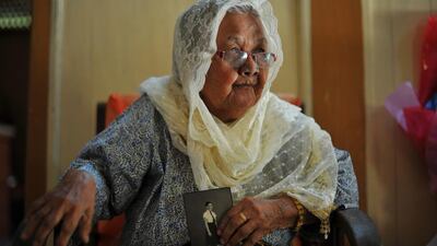 Hasnah Abdul Wahab holds an old portrait of her younger sister, Siti Aishah Abdul Wahab, at her house in Jelebu, outside Kuala Lumpur. Mohammed Rasfan / AFP
