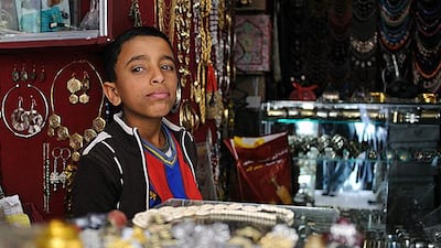 Ahmed Shahadi, 12, works behind the counter of the jewellery shop in Sanaa. Twenty-one per cent of boys and a quarter of girls have dropped out of school so they can work full time or are working part time. Photos by Lindsay Mackenzie for The National