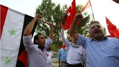 Members of the Syrian opposition living in Turkey wave Syrian and Turkish flags as they stage a protest against the Syrian regime outside the United Nations headquarters in Ankara. ADEM ALTAN / AFP PHOTO