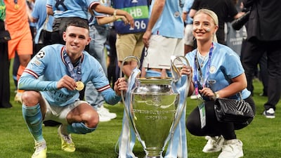 Manchester City's Phil Foden and his partner Rebecca Cooke with the UEFA Champions League cup following victory over Inter Milan. PA
