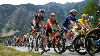 Tadej Pogacar, wearing the overall leader's yellow jersey, rides in the peloton. AP