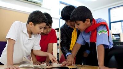 Al Ruwais Primary Boys School students choose books to borrow from the school's library.