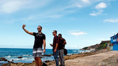 A man takes a selfie with his friends in the neighbourhood of La Perla. Ricardo Arduengo / AFP