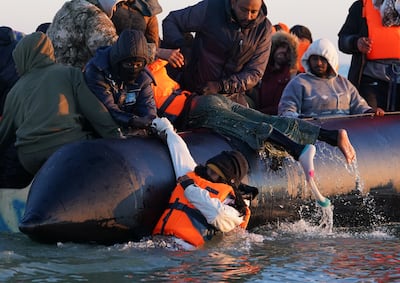 People rush to board a small boat off the coast of France, during an attempt to cross the English Channel. PA