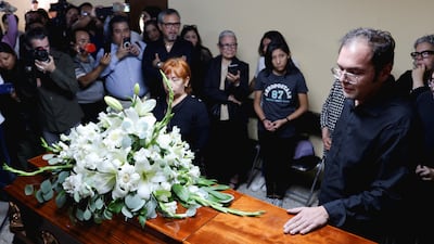 Carlos Leyva, son of journalist Francisco Alejandro Leyva, who was shot dead in the town of San Pablo Etla, stands beside his father's casket during the funeral in Oaxaca, Mexico. Reuters