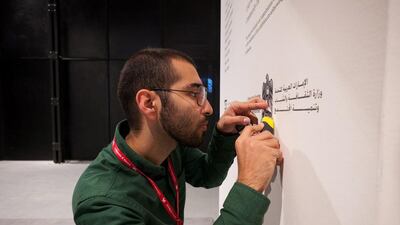 Bahar Al Bahar putting the finishing touches on the exhibition wall text ahead of the opening at the UAE's National Pavilion. (Courtesy: Bahar Al Bahar)