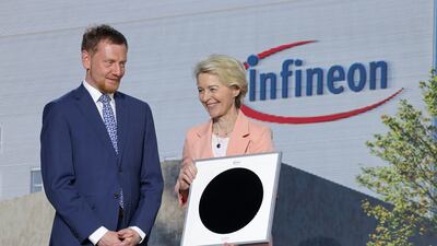 Ursula von der Leyen holds a 300mm semiconductor wafer alongside Saxony Premier Michael Kretschmer at the new Infineon factory in Dresden on Tuesday. Getty