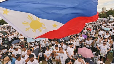 A man waves a flag as he participates in the National Rally for Peace organised by a religious group in support of Philippine Vice President Sara Duterte, who is facing impeachment complaints, in Manila, on January 13. AP