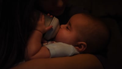 A Texas mother feeds her 5-month-old daughter a bottle of formula from the family's last container as they struggle to find more. Reuters