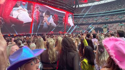 Fans cheer as Swift performs on stage. PA