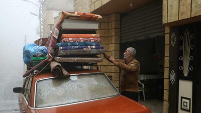 A resident who fled from Shebaa unloads personal belongings upon returning home. AFP