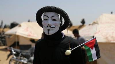 A Palestinian demonstrator wears a mask with a tire during a protest at the Israel-Gaza border in the southern Gaza Strip. Ibraheem Abu Mustafa / Reuters