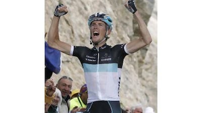 Andy Schleck celebrates his victory as he cycles past the finish line to win the 18th stage of the Tour de France yesterday.