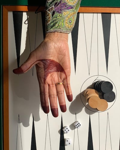 One of a series of photographs taken by Emirati photographer Alia Al Joker shows an Emirati woman's hand with a traditional board game. Alia Al Joker