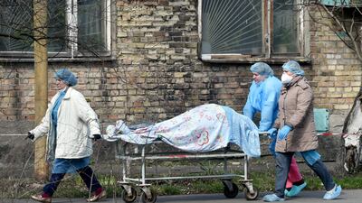 Medical workers carry a body on a stretcher from an hospital to the morgue in Kiev as Ukraine registered this week a record number of deaths and hospitalisations due to the Covid-19. Coronavirus unit is overwhelmed by patients who are admitted to the hospital round the clock as the country's aging healthcare system struggles to cope with the spread of the virus. AFP