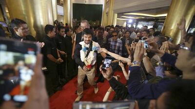 Pacquiao is greeted by a crowd as he arrives at the financial district of Makati, south of Manila. Aaron Favila / AP Photo
