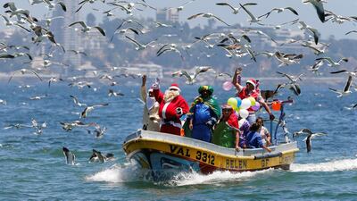 A man dressed in a Santa Claus outfit waves to people from a fisherman's boat on Christmas Eve along the coast of Valparaiso, Chile, on December 24, 2017. Rodrigo Garrido / Reuters