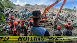 Search and rescue teams look for people after a landslide at the landfill in Barangay Binaliw, Cebu City. Rescue workers searched on January 9 for dozens of people buried under a mountain of garbage that collapsed at a landfill in the central Philippines, killing at least one. AFP