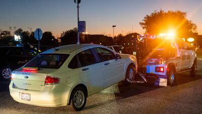 Under police supervision, a tow truck tows the shooter's car from the scene. EPA
