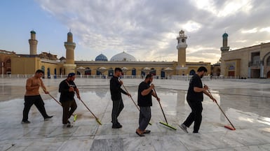 Workers clean the courtyard at the shrine of Sheikh Abdul Qadir Al Kilani in central Baghdad, where the number of Muslim pilgrims has declined due to the impact of the Iran war. AFP