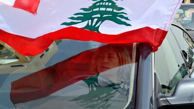 An anti-government protester puts a Lebanese flag on her car during a parade to protest the economic situation in downtown Beirut, Lebanon, EPA
