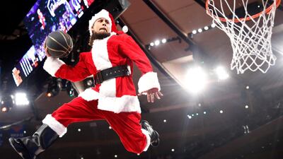A "dunking Santa" uses a trampoline to get airborne during a timeout in the NBA game between the New York Knicks and Washington Wizards on Monday, Deccember 23, 2019. The Wizards won 121-115. AP