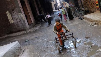A boy rides a bicycle through the streets of the Bashteel district of Imbaba.