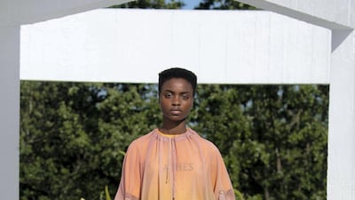 A loose shift tunic in translucent peach is layered over a T-shirt that reads 'Ashes', inspired by a book by the poet Adunis. Courtesy Qasimi