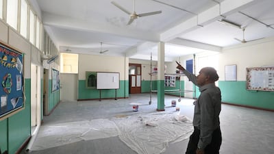 The vice principal at the Sheikh Khalifa (Pakistani) School on Muroor Road in Abu Dhabi points out damage to the ceiling which will get a repair and paint job before kids return to class this week. (DELORES JOHNSON / The National )