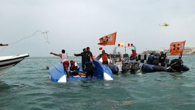 Rescuers at the scene of the crash during yesterday's Dubai Grand Prix race in which both pilots died.