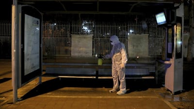 A Revolutionary Guard member disinfects a bus station in Tehran, Iran, March 4. AP