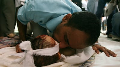 A Yemeni man kisses the face of his dead son after he was killed during clashes between anti-government protesters and security forces in Sanaa on September 19, 2011. Mohammed Huwais / AFP Photo