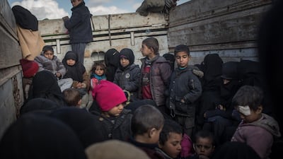 Women and children who have fled fighting in Bagouz look out the back of a truck. Getty Images